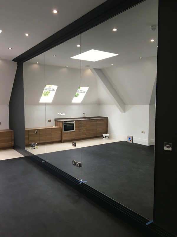 Frameless glass partition in loft conversion by Barnes glaziers